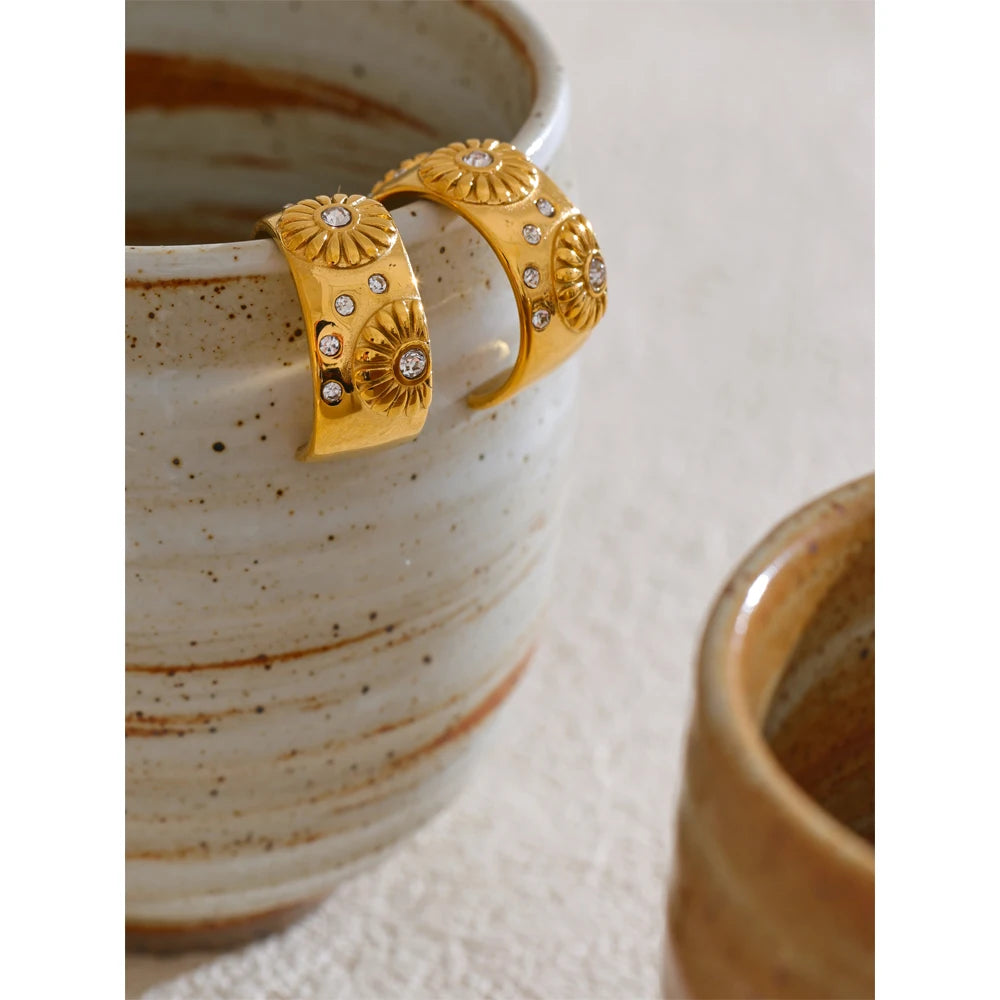 Orecchini huggie dorati con dettagli floreali