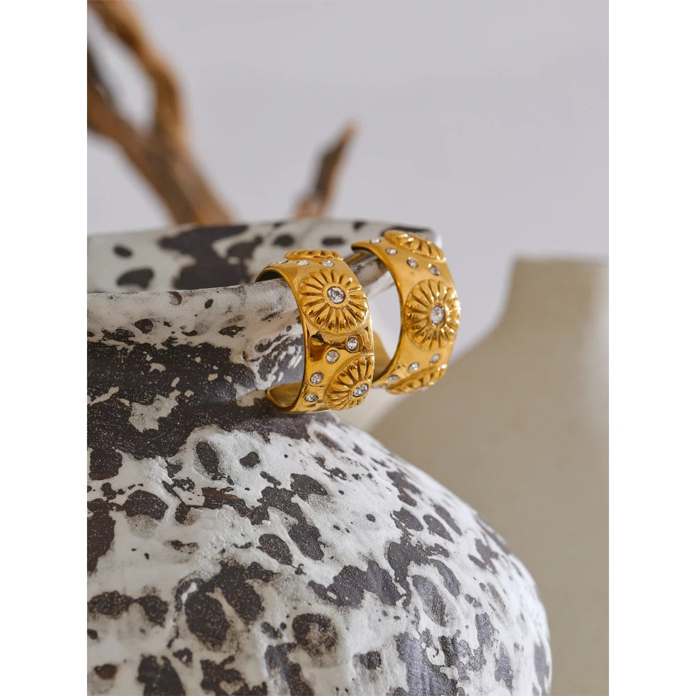 Orecchini huggie dorati con dettagli floreali